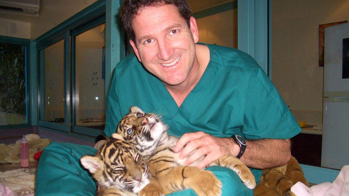 Andy Goldfarb cuddles two tiger cubs.