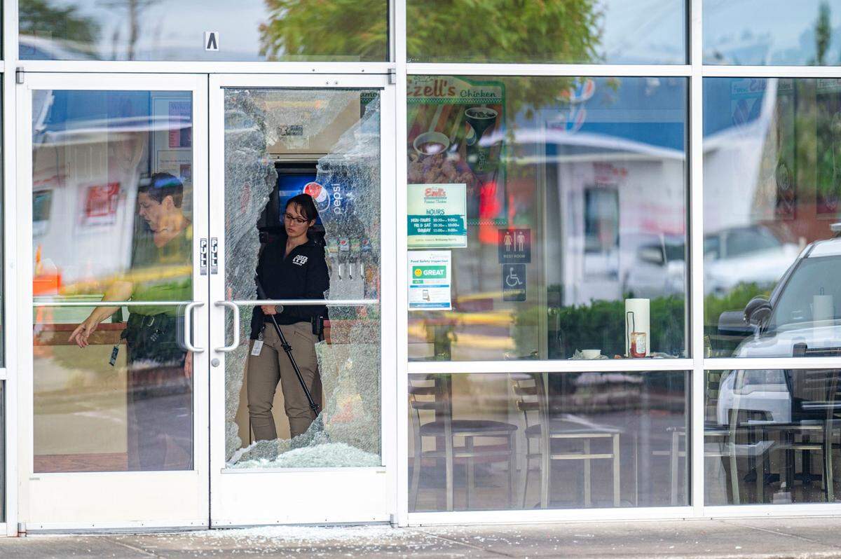 Tacoma Police Department crime-scene technicians and detectives investigate inside Ezell’s Chicken near where a shooting took place on Wednesday, July 6, 2022, in the South 1900 block of Martin Luther King Jr. Way in Tacoma, Wash.