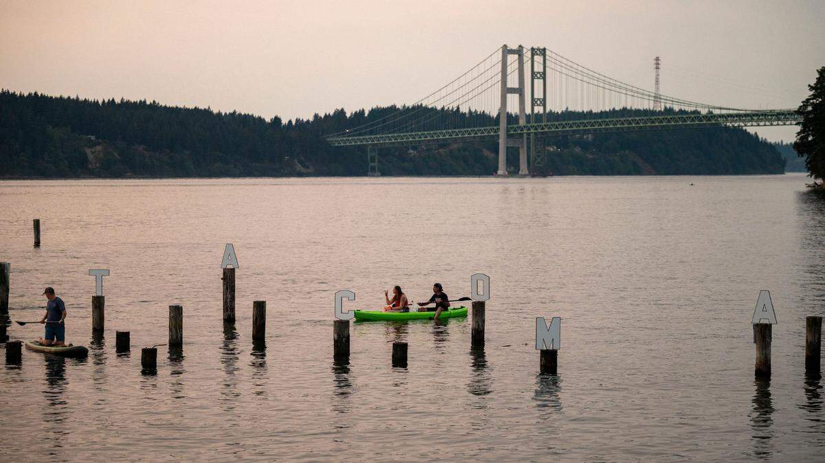 John James Nelson sits in a kayak with his daughter, Kyleena Shipman, making sure all the letters that spell out “Tacoma” are standing straight and attached to the proper off-shore pilings near Titlow Beach on Friday, Aug. 9, 2024, in Tacoma, Wash.