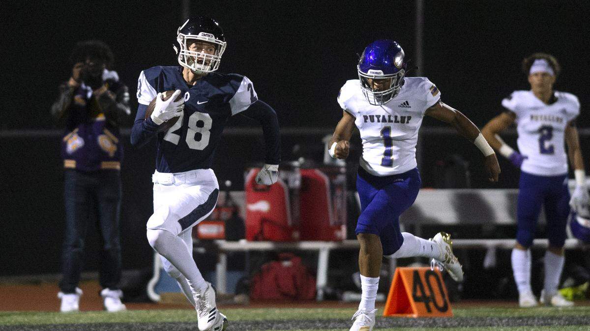 Olympia wide receiver Will Anderson races for a touchdown in front of Puyallup defensive back Isaiah Dickerson on the Bears’ first play from scrimmage during Friday night’s 4A SPSL football game at Ingersoll Stadium in Olympia on Oct. 11, 2019.