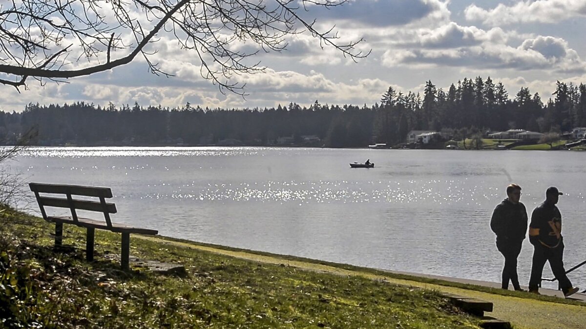 Men stroll along Spanaway Lake in Spanaway Lake Park, Feb. 21, 2019.