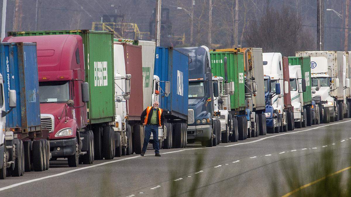 Dozens of trucks towing shipping containers line up along State Route 509 near the Port of Tacoma. Completion of the $2 billion Puget Sound Gateway Project, which would relieve congestion on SR 509 and SR 167, received funding in the transportation budget the Legislature is sending to the governor.