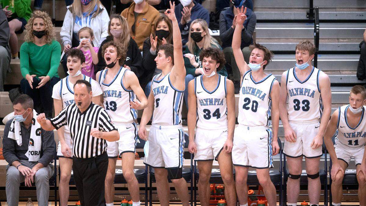 The Olympia bench celebrates a three-point shot as the Bears pull away from the Graham-Kapowsin Eagles in the second half of Friday night’s 4A SPSL league tournament boys basketball semifinal game at Olympia High School on Feb. 4, 2022.