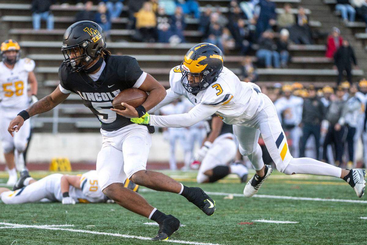 Lincoln quarterback Gabarri Johnson scrambles away from a tackle attempt by Bellevue’s Ishaan Daniels during the first quarter of a Class 3A state quarterfinal game on Saturday, Nov. 19, 2022, at the Lincoln Bowl in Tacoma, Wash.