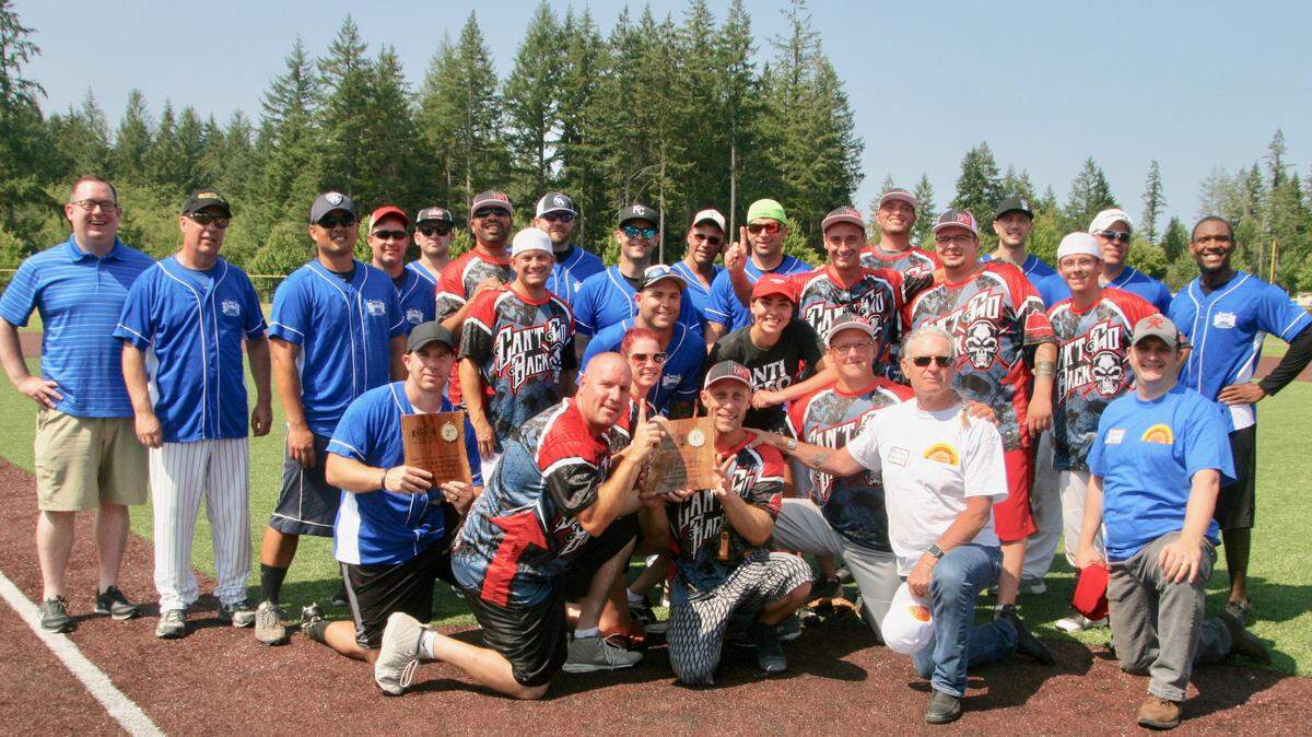 Right, in white shirt, Jeremiah Saucier, director of the Hope Recovery Center, sponsor of the fourth annual Guns and Hoses softball tournament, awards the tourney’s first and second place trophies respectively to the Can’t Go Back team and the Guns law enforcement team.