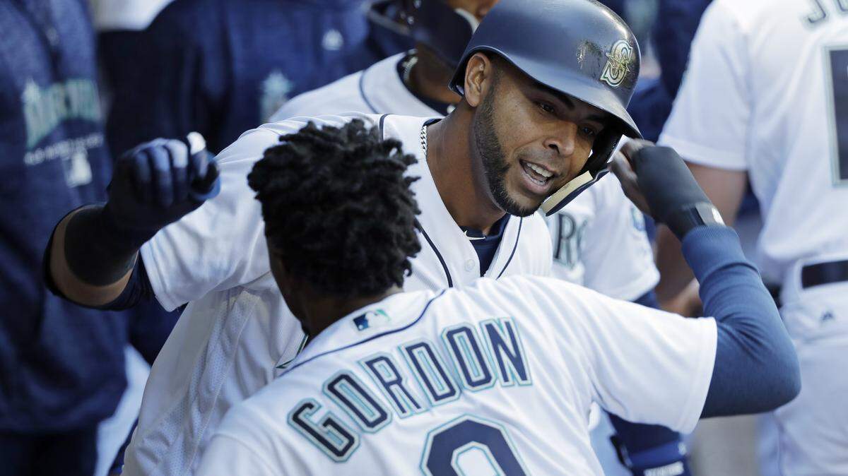 Seattle Mariners' Nelson Cruz, right, celebrates with Dee Gordon in the dugout after hitting a two-run home run against the Cleveland Indians on March 31. Moments later Cruz sprained his ankle in the dugout and has not played since.