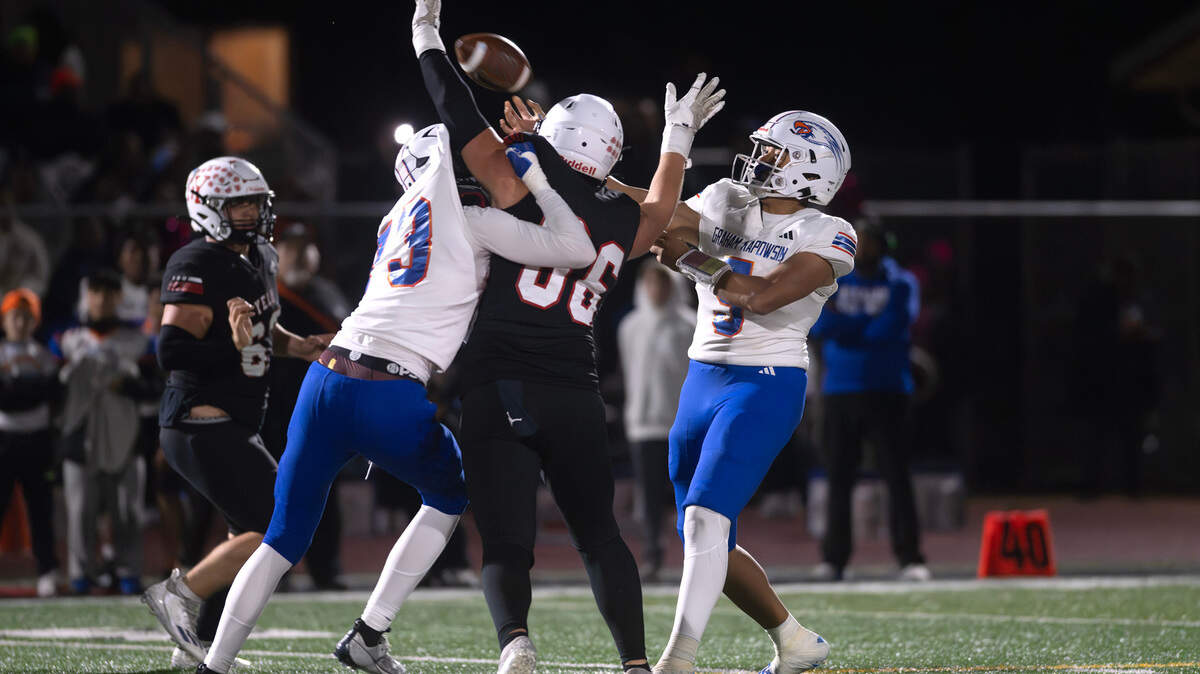 Graham Kapowsin quarterback Aloalii Faafolua delivers a touchdown pass under pressure from Yelm defensive lineman Chris Hauss during Friday night’s football game at Yelm High School in Yelm, Washington, on Oct. 4, 2024.