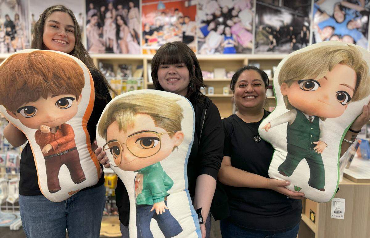 KPOP Station staff members (from left) Azadeh Walner, Kyo Hosfield and Thalia Maldonado hold plushies representing BTS members Jin, Jimin and V at the Tacoma Mall.