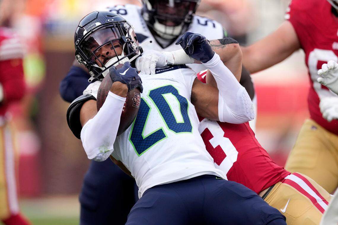 Seattle Seahawks safety Julian Love (20) is tackled by San Francisco 49ers running back Christian McCaffrey after intercepting a pass during the first half of an NFL football game in Santa Clara, Calif., Sunday, Dec. 10, 2023. (AP Photo/Godofredo A. Vásquez)
