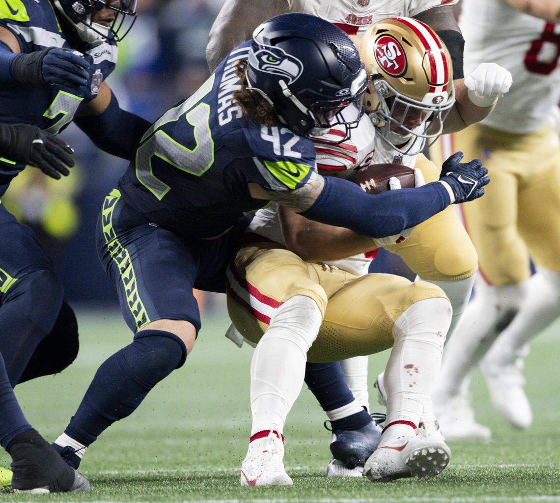 Seattle Seahawks linebacker Drake Thomas (42) tackles San Francisco 49ers running back Christian McCaffrey (23) for a loss during the third quarter of the NFC Divisional Round game at Lumen Field, on Saturday, Jan. 17, 2026, in Seattle.