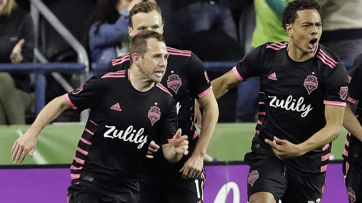 Seattle Sounders midfielder Harry Shipp, left, celebrates with teammates, including midfielder Henry Wingo (23) after Shipp scored a goal against the San Jose Earthquakes during the second half of an MLS soccer match, Wednesday, April 24, 2019, in Seattle. The match ended in a 2-2 tie. (AP Photo/Ted S. Warren)