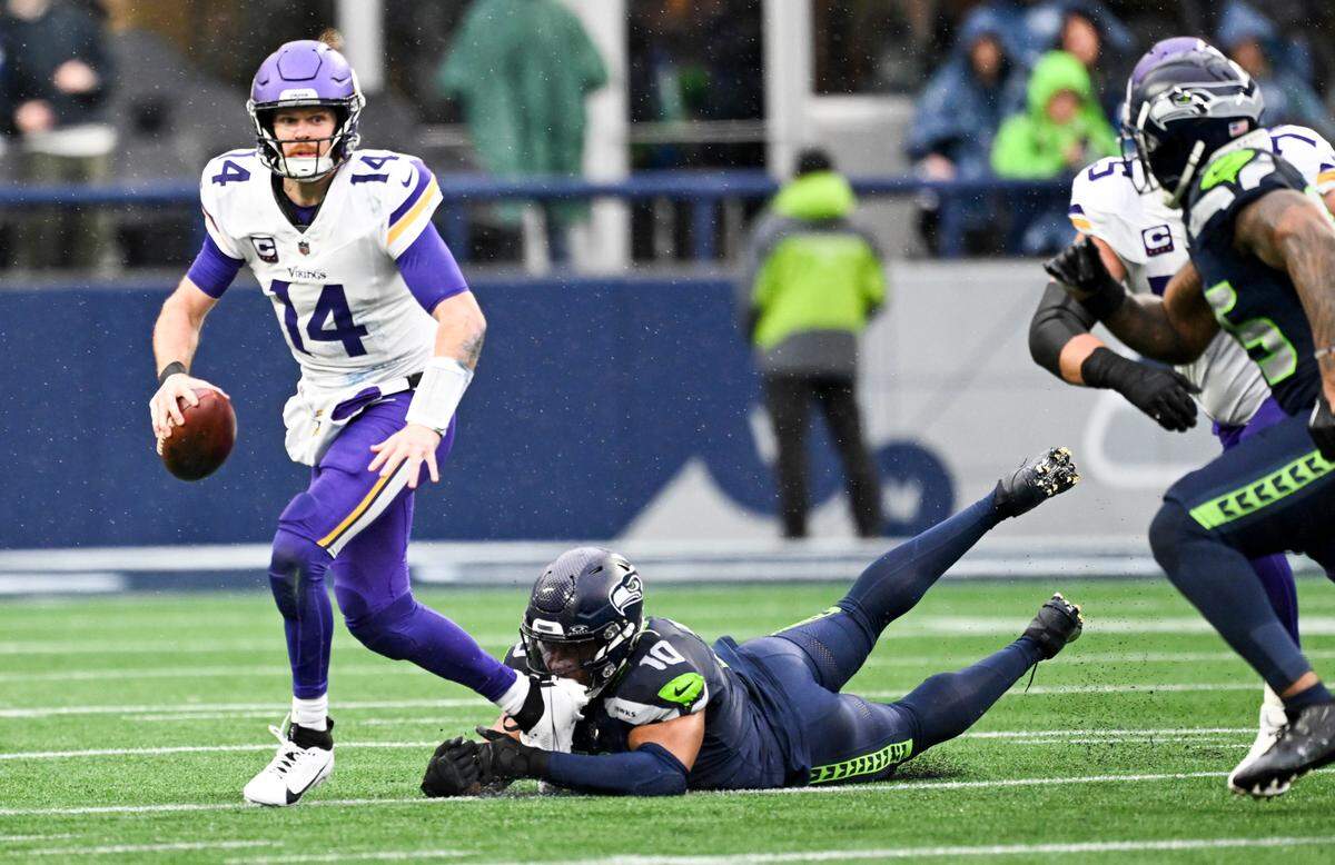 Minnesota Vikings quarterback Sam Darnold (14) evades Seattle Seahawks linebacker Uchenna Nwosu (10) during the first quarter of the first quarter of the game at Lumen Field, on Sunday, Dec. 22, 2024, in Seattle, Wash.