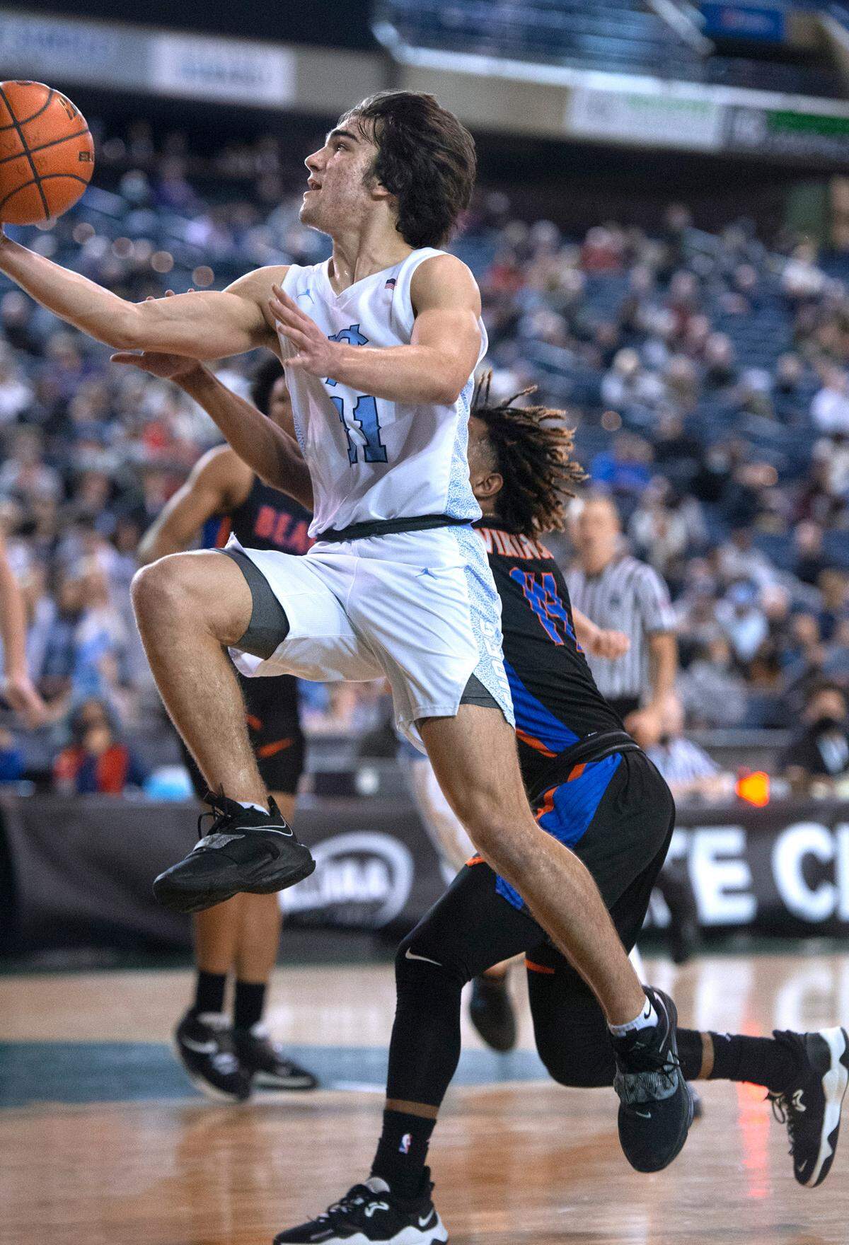 Gig Harbor’s Christian Parrish flies down the lane against Rainier Beach defender Nahmier Robinson during Thursday afternoon’s quarterfinal game of the WIAA 3A Boys Basketball State Championships tournament in the Tacoma Dome in Tacoma, Washington, on Thursday, March 3, 2022. Rainier Beach won the game, 65-60.