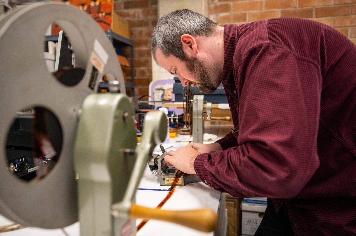 Filmmaker and director, Isaac Olsen repairs original film of the iconic Rainier beer television commercials from the 1970’s and 1980’s in his studio in Tacoma, Wash. on Sept. 20, 2022. The Washington State Historical Society lent Olsen the original film from the making of the commercials.