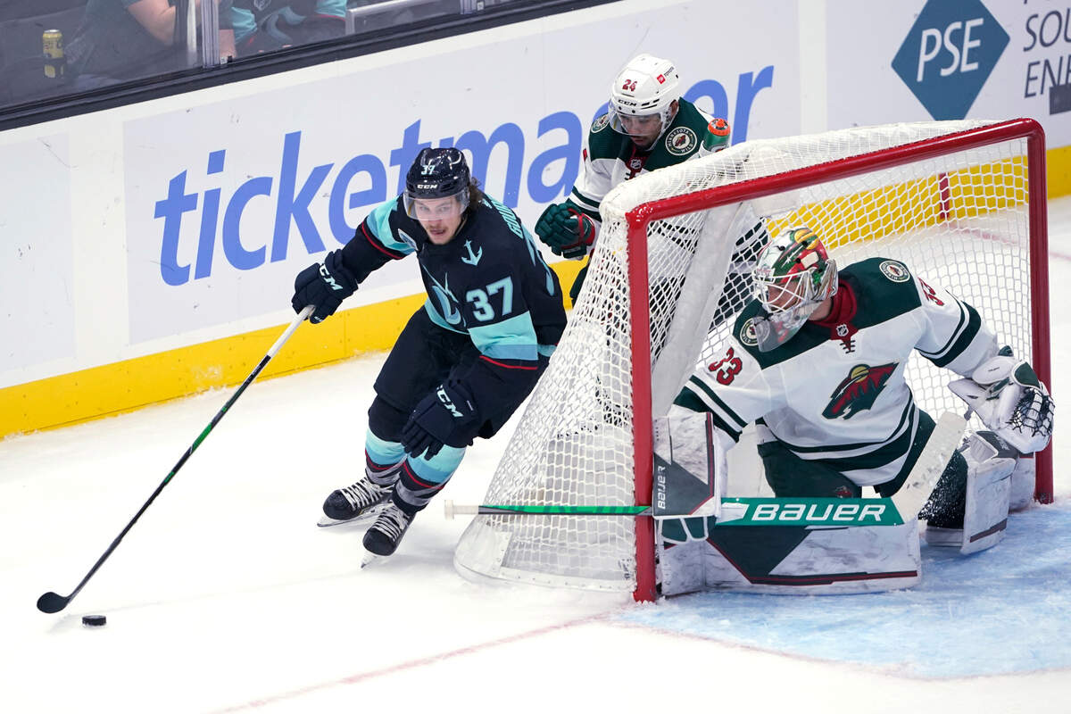Seattle Kraken center Yanni Gourde (37) skates behind Minnesota Wild goaltender Cam Talbot (33) during the second period of an NHL hockey game Thursday, Oct. 28, 2021, in Seattle. (AP Photo/Ted S. Warren)