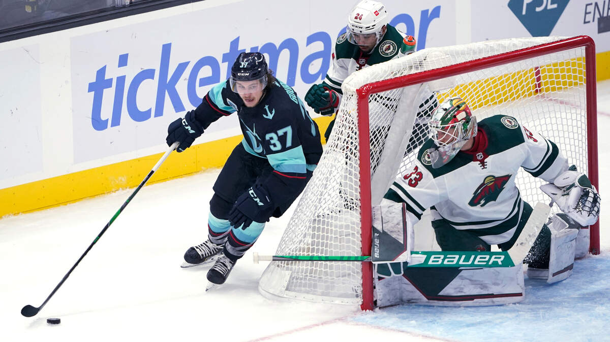Seattle Kraken center Yanni Gourde (37) skates behind Minnesota Wild goaltender Cam Talbot (33) during the second period of an NHL hockey game Thursday, Oct. 28, 2021, in Seattle. (AP Photo/Ted S. Warren)
