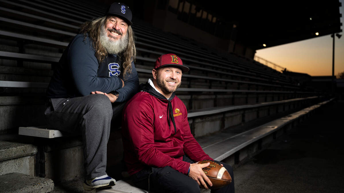 Sumner High School football coach Keith Ross, left, and Enumclaw High School football coach Mark Gunderson, right, pose for a portrait in the bleachers at Sunset Chev Stadium in Sumner, Wash. on Nov. 16, 2022.
