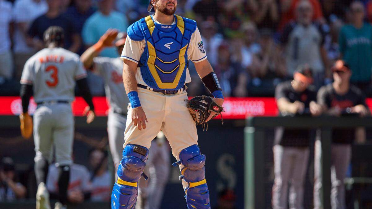 Seattle Mariners catcher Cal Raleigh, foreground, reacts after Baltimore Orioles’ Jorge Mateo (3) scored during the ninth inning of a baseball game, Sunday, Aug. 13, 2023, in Seattle. (AP Photo/John Froschauer)