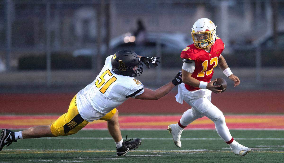 Mount Tahoma quarterback Tre Walker scrambles to escape from Lincoln defensive lineman Brad Amsden during Friday night’s football game at Mount Tahoma High School in Tacoma, Washington, on Sept. 20, 2023. Mount Tahoma won the game, 24-20.