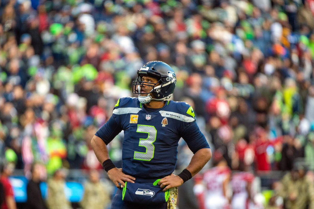 Seattle Seahawks quarterback Russell Wilson (3) looks up at the video board as a play in reviews by the officials during the third quarter of an NFL game against the Arizona Cardinals on Sunday afternoon at Lumen Field in Seattle. The referee crew was reviewing the interception and return by Seattle Seahawks cornerback Sidney Jones (23). The interception was overruled by the officials and Arizona was retained possession of the ball.
