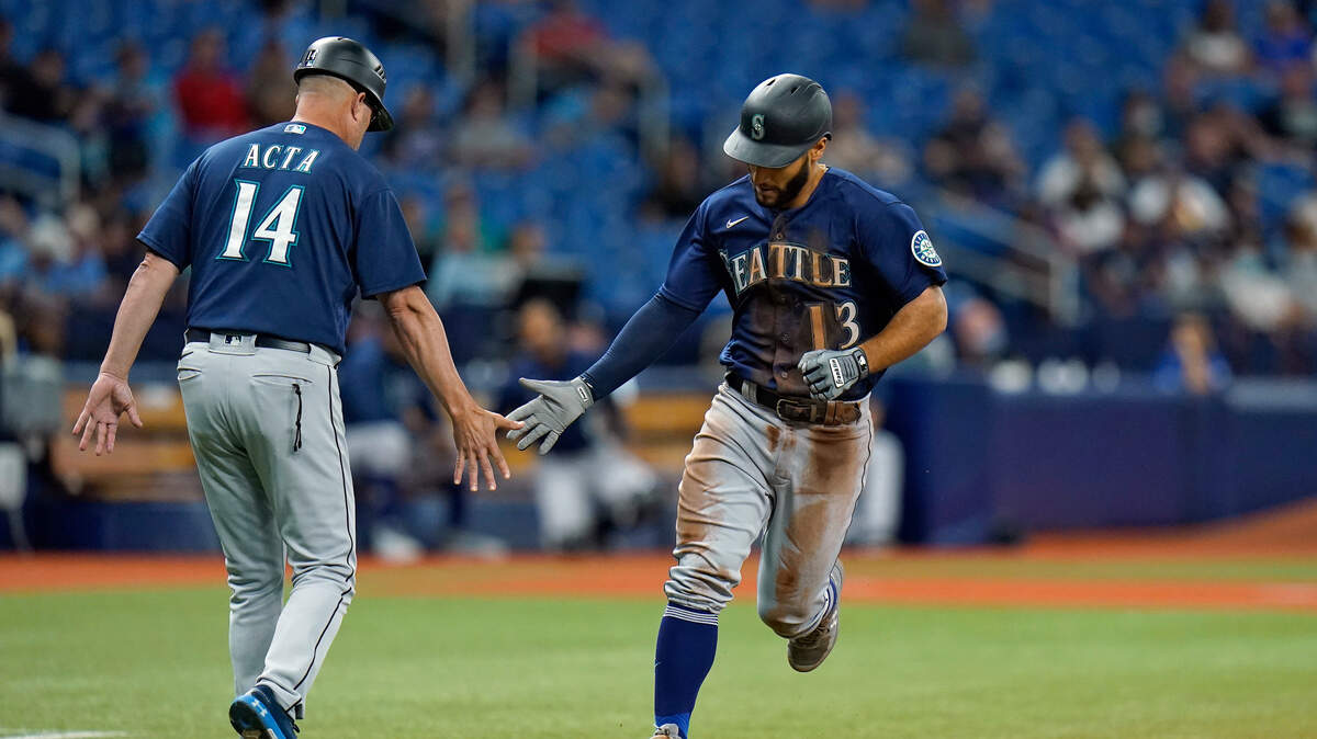 Seattle Mariners’ Abraham Toro (13) shakes hands with third base coach Manny Acta (14) after his solo home run off Tampa Bay Rays pitcher Luis Patino during the fourth inning of a baseball game Tuesday, Aug. 3, 2021, in St. Petersburg, Fla. (AP Photo/Chris O’Meara)