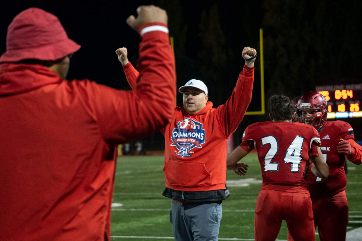 Kennedy Catholic head coach Sheldon Cross holds up his arms victoriously with less than a minute remaining in the fourth quarter of a Class 4A state quarterfinal game Skyline on Friday, Nov. 18, 2022, at Highline Memorial Stadium in Burien, Wash. Kennedy Catholic beat Skyline, 38-10.