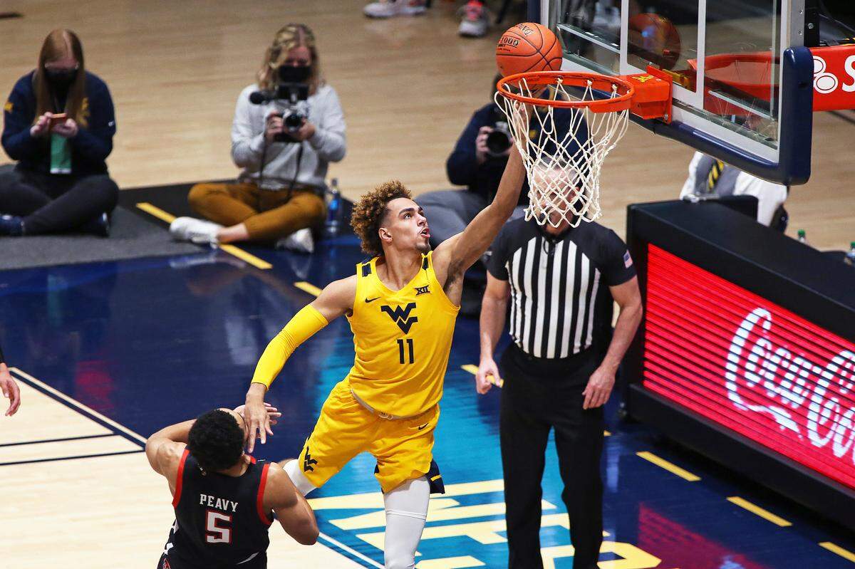 West Virginia forward Emmitt Matthews Jr. (11) shoots while defended by Texas Tech guard Micah Peavy (5) during the second half of an NCAA college basketball game Monday, Jan. 25, 2021, in Morgantown, W.Va. (AP Photo/Kathleen Batten)