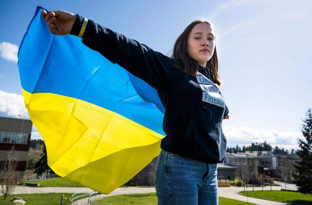 Anastasiya “Ana” Lemesh poses for a portrait with a Ukrainian flag on the Pierce College Fort Steilacoom campus in Lakewood, Wash. on Thursday, March 31, 2022. Lemesh is from Chernihiv, Ukraine and has been an exchange student in the U.S. for approximately three months.