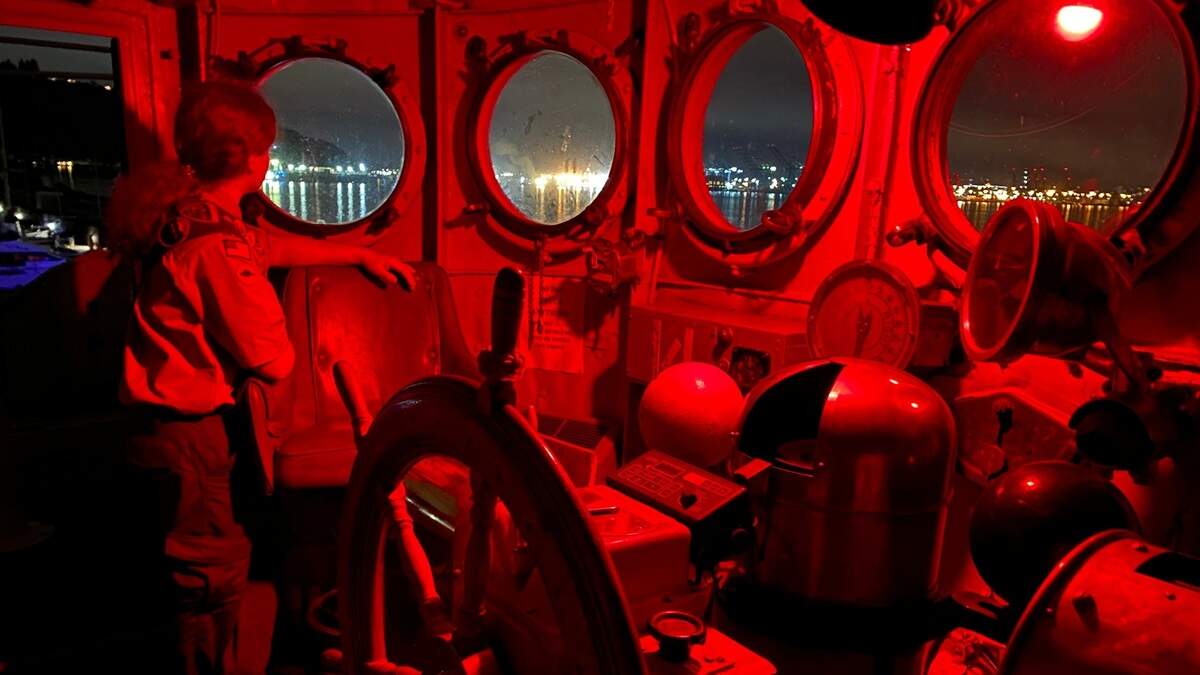 Boy Scout Connor Hazel looks at the lights of Tacoma on Tuesday evening from inside the bridge of the USCGC Comanche, moored at Tyee Marina. Hazel, 18, installed a new fantail deck on the ship’s stern as a project to earn his Eagle Scout rank. A new nonprofit has taken over the restoration of the ship. 