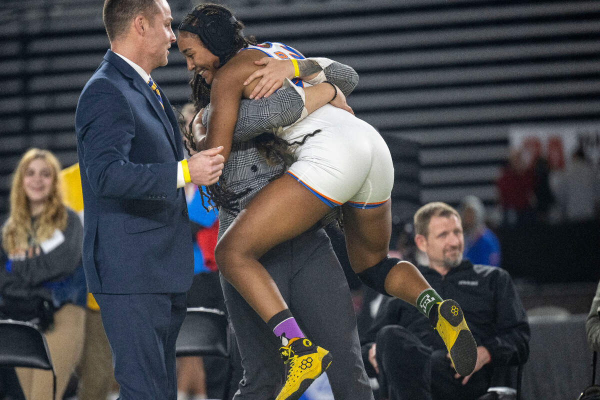 Flor Parker-Borrero hugs her sister and coach Jasmine Parker-Borrero after beating Camas’ Addie Wunderli in the 140-pound, Girls 3A/4A division’s championship match at Mat Classic XXXIV on Saturday, Feb. 18, 2023, at the Tacoma Dome in Tacoma, Wash.