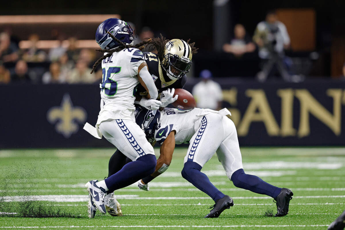 New Orleans Saints running back Alvin Kamara (41) has the ball knocked out by Seattle Seahawks safety Ryan Neal (26) during an NFL football game, Sunday, Oct. 9, 2022, in New Orleans. (AP Photo/Tyler Kaufman)