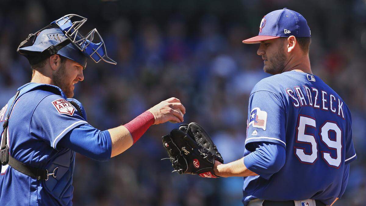 Texas Rangers catcher Jett Bandy, left, goes out to the mound to talk with pitcher Connor Sadzeck (59) in the third inning of a spring training baseball game against the Chicago Cubs, Friday, March 22, 2019, in Mesa, Ariz. (AP Photo/Sue Ogrocki)