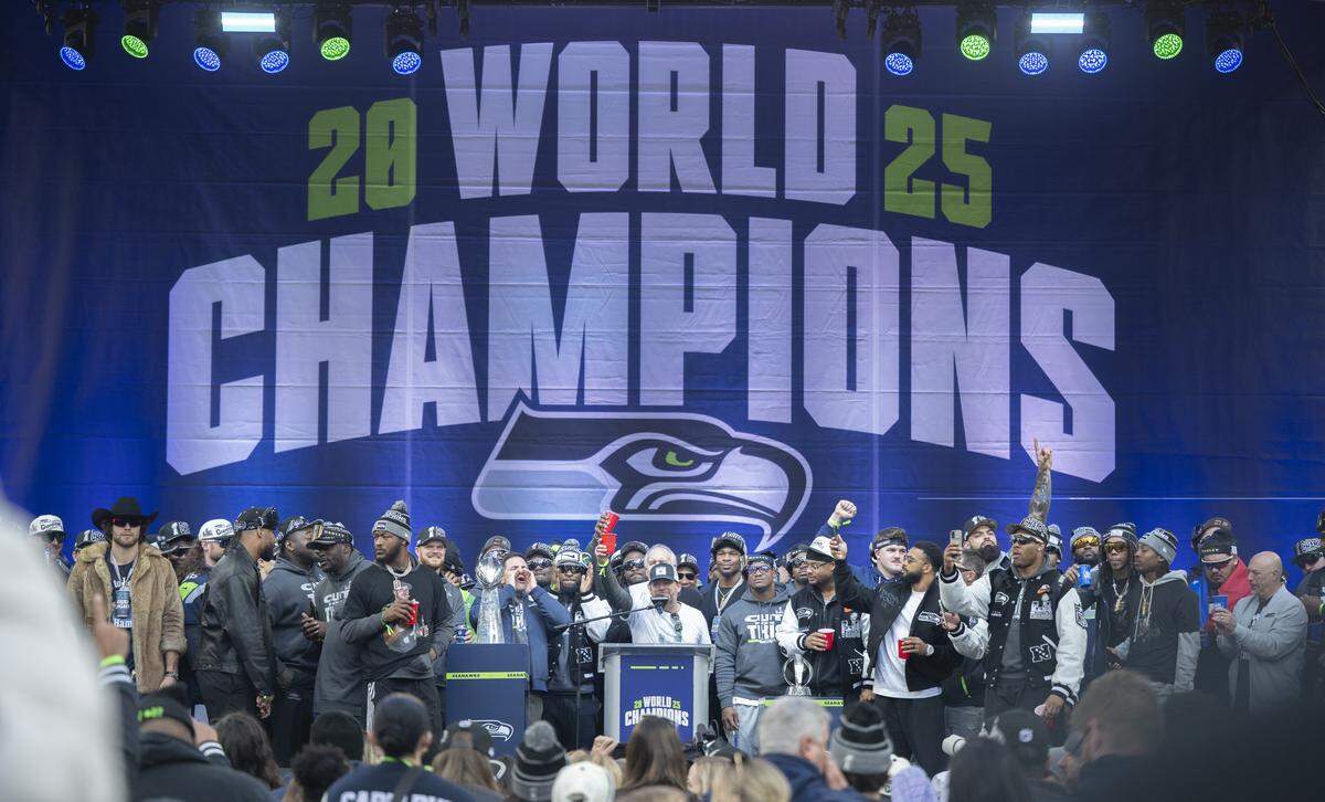 Seahawks general manager John Schneider raises his cup while talking to the crowd at the team’s Trophy Celebration event at Lumen Field on Wednesday, Feb. 11, 2026, in Seattle.