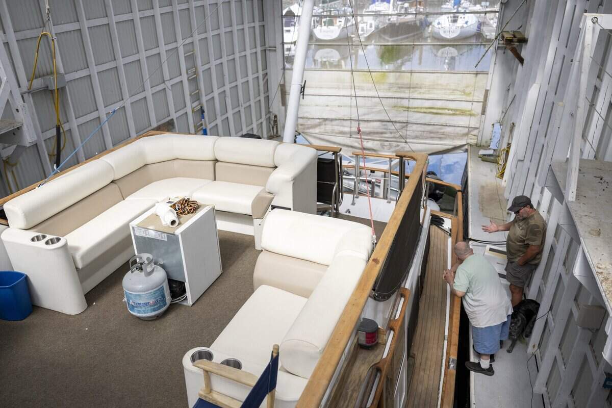 Toni Froehling, left, speaks with his subleaser, David Russel, at Froehling's boat house stationed at Breakwater Marina on Tuesday, May 12, 2026, in Tacoma, Wash. Froehling says dismantling the boathouse would cost him thousands of dollars.