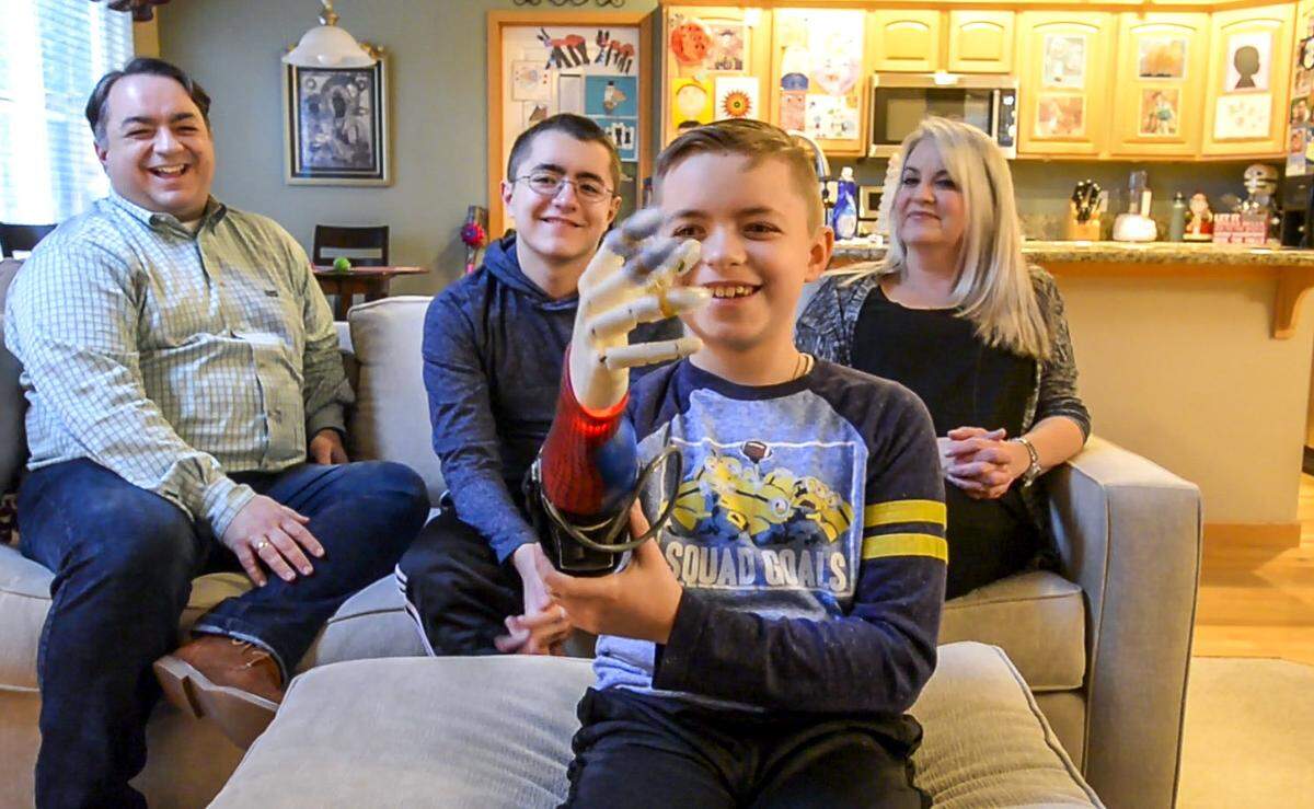 10-year-old Zachary Pamboukas shows his ‘bionic’ prosthetic arm, January 4, 2019. The Maple Valley boy was born with part of his right arm missing, and got his prosthetic free from Limbitless Solutions. Behind is his family, Niko (left), Christo and Rachael Pamboukas.