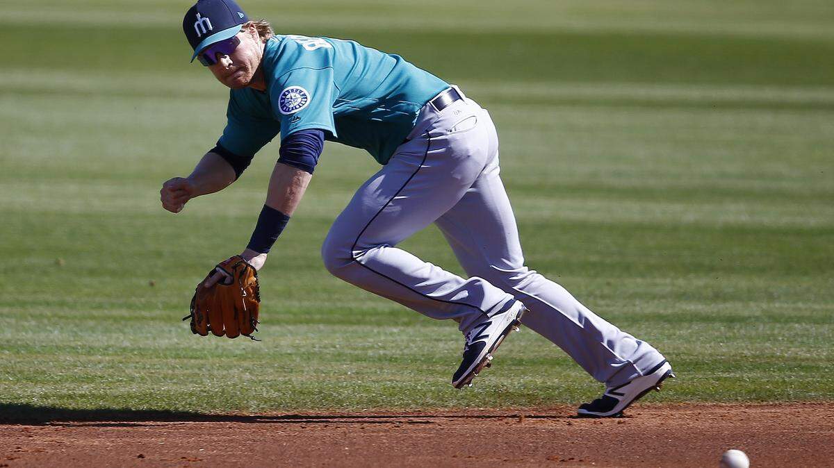 Seattle Mariners second baseman Gordon Beckham tries to chase down a grounder hit by Cleveland Indians' Lonnie Chisenhall during the first inning of a spring training baseball game Wednesday, Feb. 28, 2018, in Goodyear, Ariz. Mariners' Beckham was unable to make the play, but teammate Andrew Romine was able to field the grounder and get Indians' Chisenhall out at first base. (AP Photo/Ross D. Franklin)