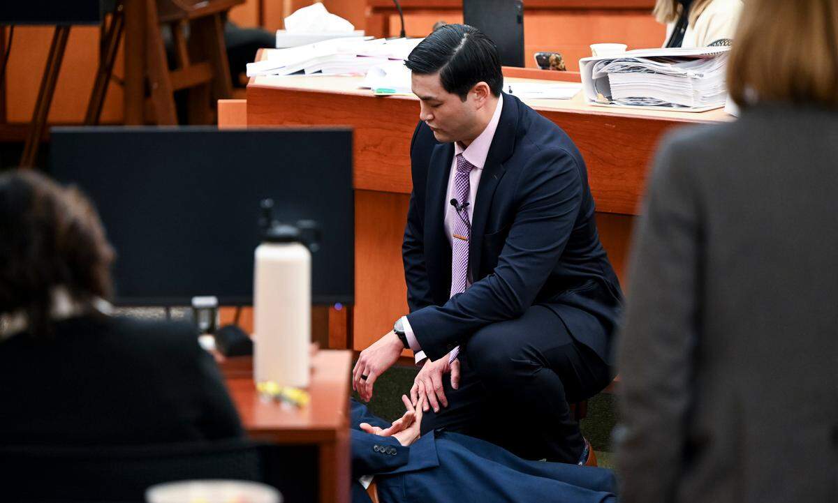 Defendant Timothy Rankine demonstrates where officers were located on Manny Ellis, using defense attorney Mark Conrad as a stand in, during the trial of three Tacoma Police officers in the killing of Manny Ellis at Pierce County Superior Court, Tuesday, Dec. 5, 2023, in Tacoma, Wash. Tacoma Police Officers Christopher Burbank, Matthew Collins and Timothy Rankine stand trial for charges related to the March 2020 killing of Manny Ellis. (Brian Hayes / Pool Photo – The News Tribune)