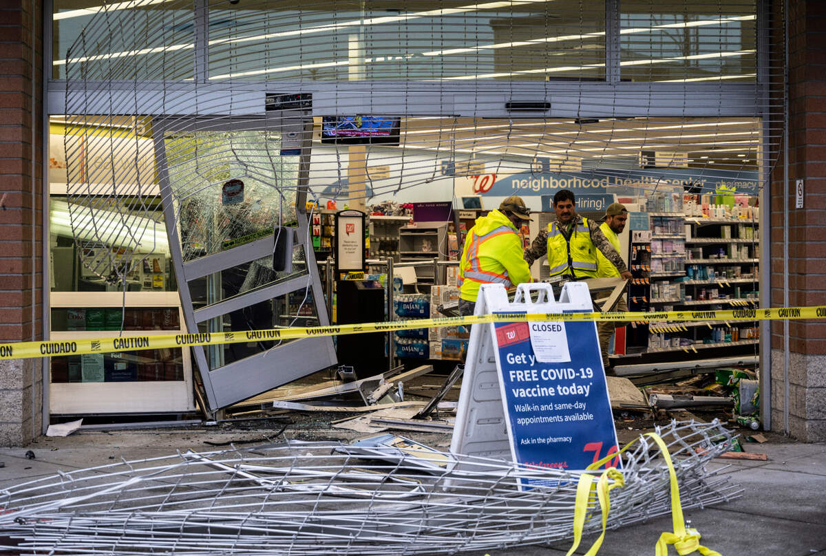 A crew works to remove the broken doors and other damage done to the entrance of Walgreens after a truck was used to break into the store on the 2000 block of Sixth Avenue in Tacoma, Wash. on Monday, March 14, 2022.