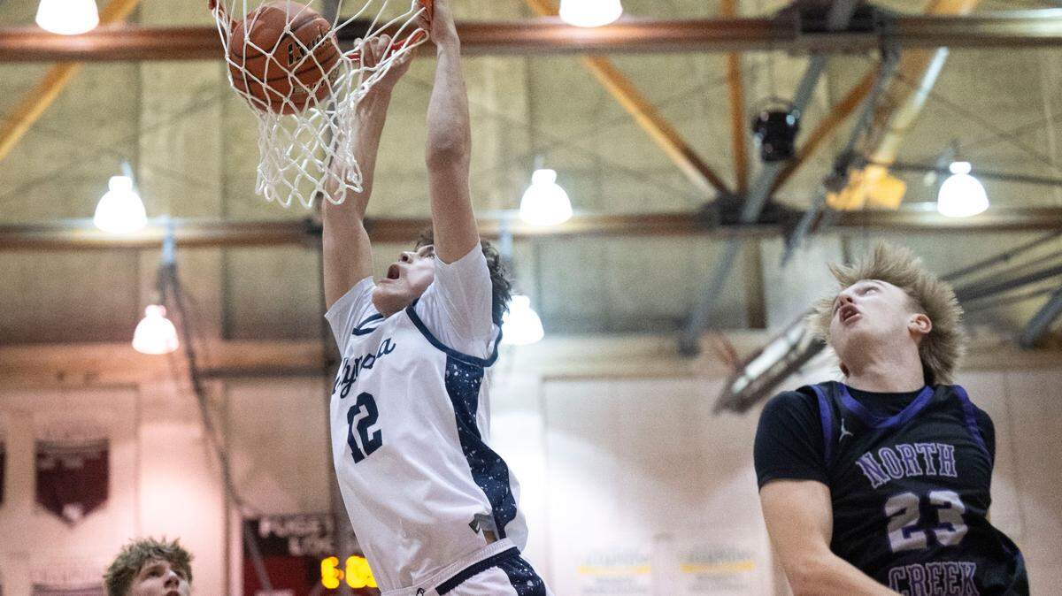 Olympia forward Brian Stevenson (12) dunks the ball as North Creek forward Kellen Joyner (23) looks on during the second quarter of a Class 4A regional round of the state tournament game on Saturday, March 1, 2025, at the University of Puget Sound in Tacoma, Wash.