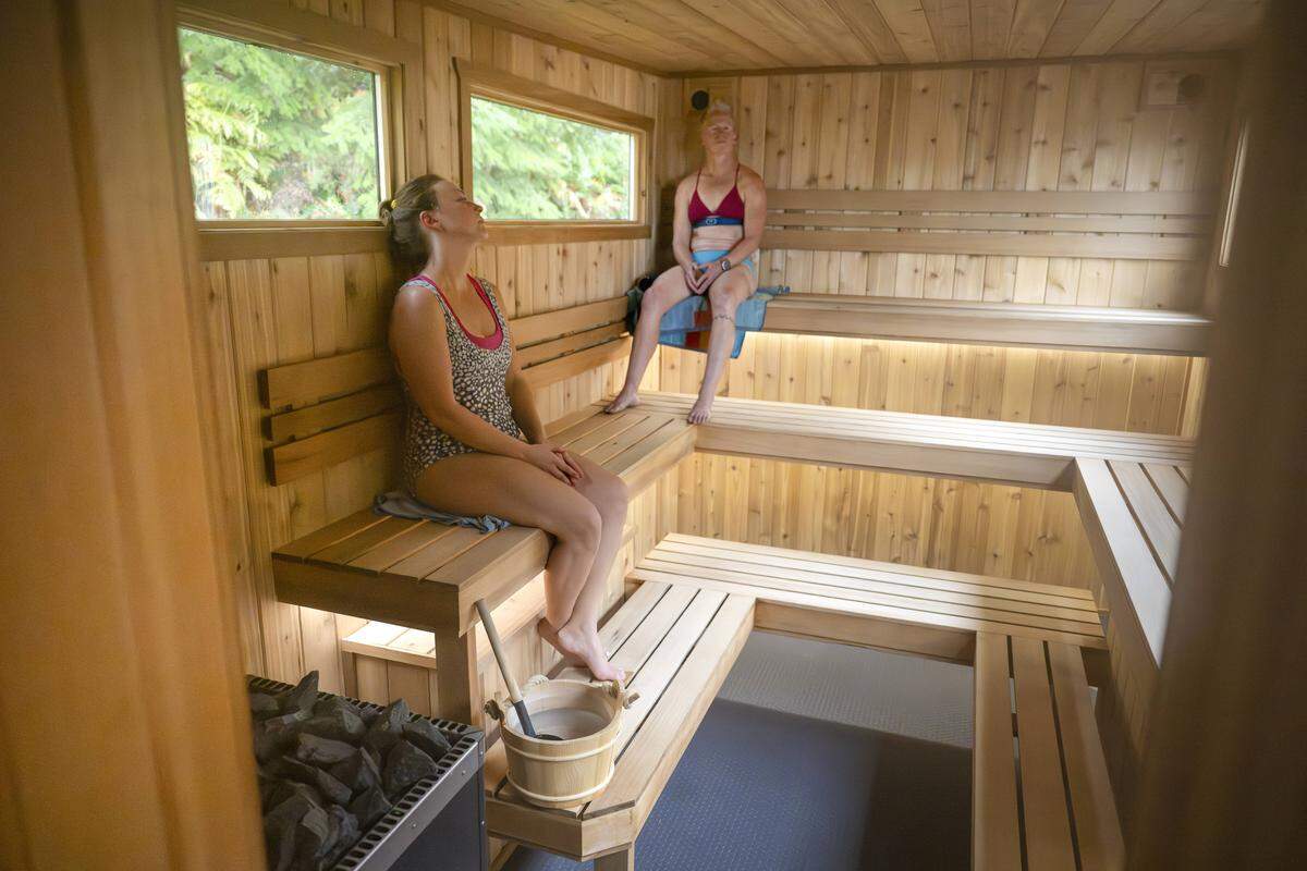 Amanda Ryken, left, and Dena Paris sit in the Svette Sauna  for a 180-degree heat session on Friday, Oct. 31, 2025, at Owen Beach in Tacoma, Wash.