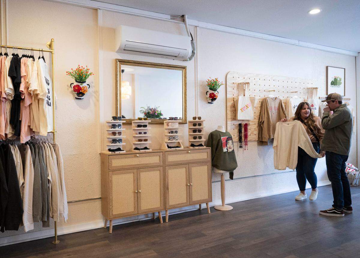 Guest peruse shirts and other items highlighting Latin culture during the soft opening of Nuestro Barrio, on Wednesday, May 1, 2024, in Puyallup, Wash.