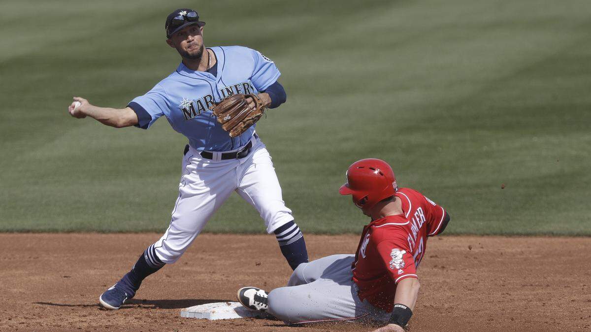 Cincinnati Reds’ Kyle Farmer is forced out at second as Seattle Mariners’ Kristopher Negron throws to first for a double play during the second inning of a spring training baseball game, Monday, Feb. 25, 2019, in Peoria, Ariz. (AP Photo/Darron Cummings)