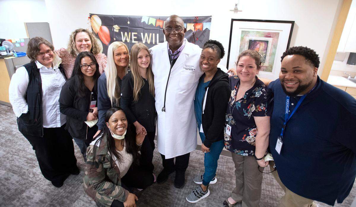 Dr. Charles Weatherby surrounded by office staff on his final day of work at the Polyclinic in Tacoma, Washington, on Thursday, March 31, 2022.