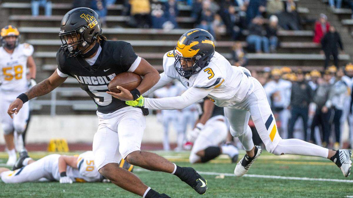 Lincoln quarterback Gabarri Johnson scrambles away from a tackle attempt by Bellevue’s Ishaan Daniels during the first quarter of a Class 3A state quarterfinal game on Saturday, Nov. 19, 2022, at the Lincoln Bowl in Tacoma, Wash.