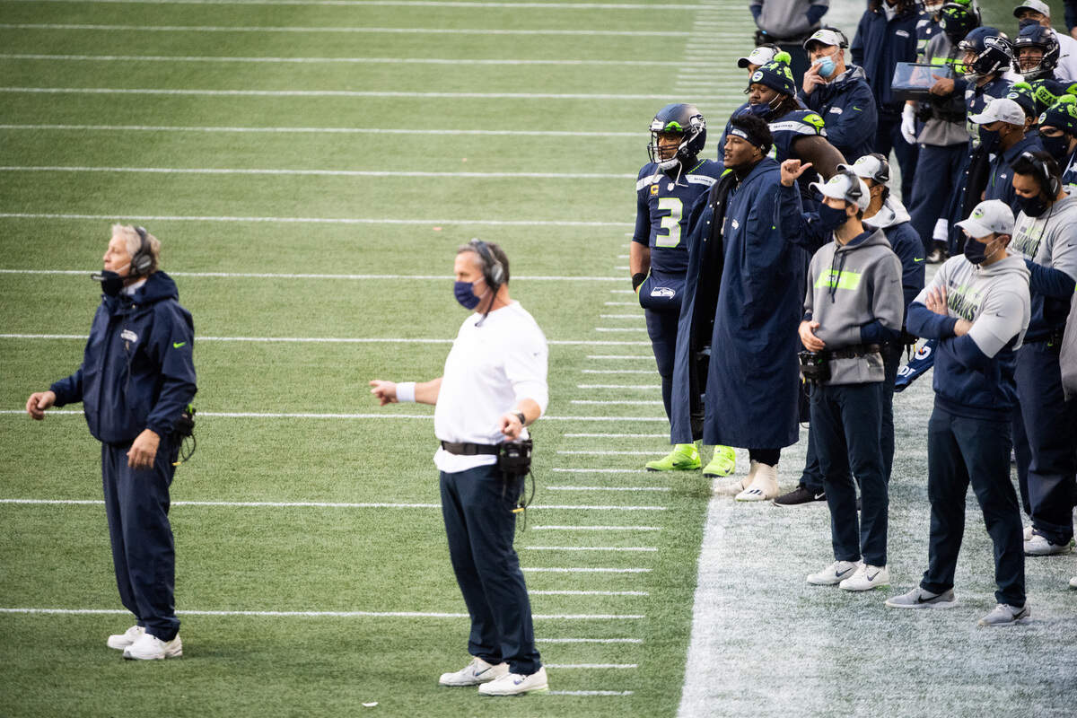 Seattle Seahawks quarterback Russell Wilson and Seattle Seahawks running back Chris Carson watch. From the sideline during the fourth quarter. The Seattle Seahawks played the New York Jets in a NFL football game at Lumen Field in Seattle, Wash., on Sunday, Dec. 13, 2020.