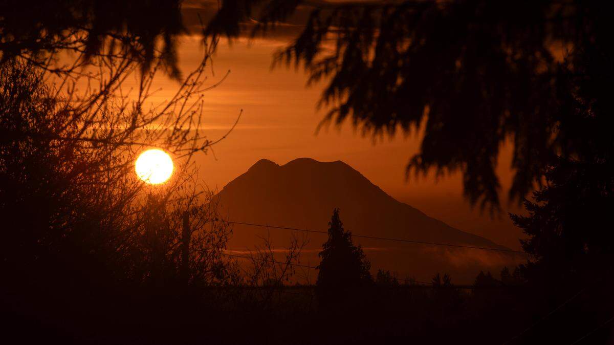 The sun rises behind Mount Rainier as seen from Tumwater, Washington, on Thursday, March 7, 2024.