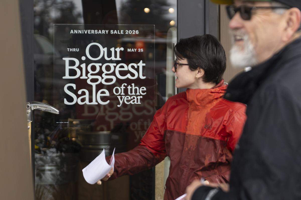 Picketers in support of REI Union workers, including Grace Dannen, center, a native of Tacoma, hand out flyers outside of an REI Co-op location on Friday, May 15, 2026, in Tacoma, Wash. The flyers share information about the union's 10-day boycott of the REI Co-op's Anniversary Sale.