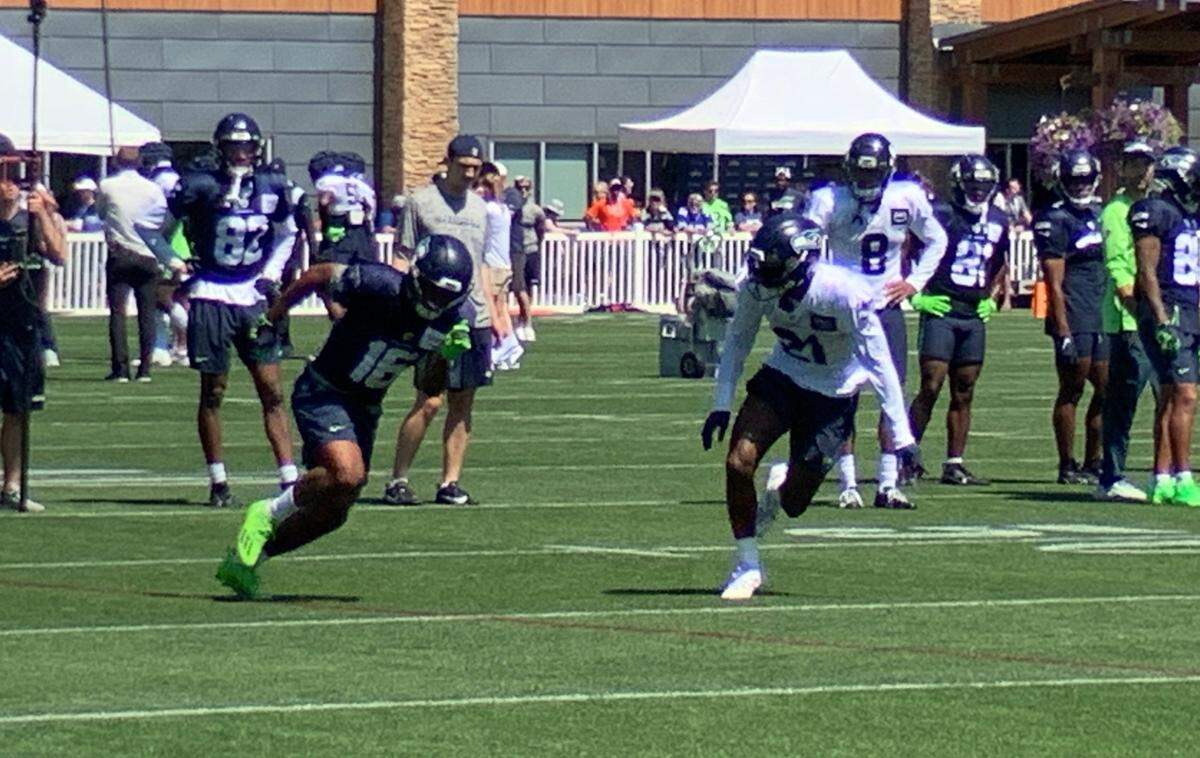 Tyler Lockett runs at rookie cornerback and first-round pick Devon Witherspoon seconds before catching a catch of a pass from Geno Smith on the first day in shoulder pads of Seahawks training camp, day five in Renton, July 31, 2023.