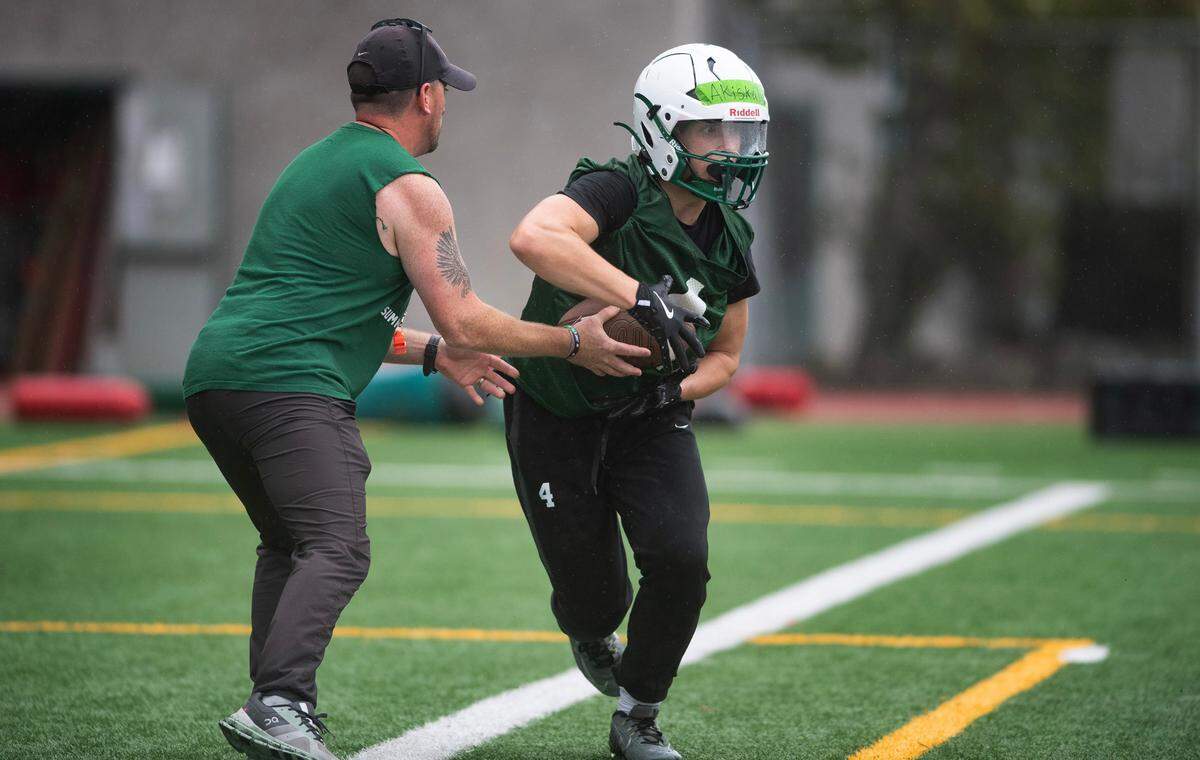 Peninsula running back Jake Akiskalian takes a handoff during preseason football practice at Peninsula High School in Purdy, Washington, on Friday, Aug. 23, 2024.