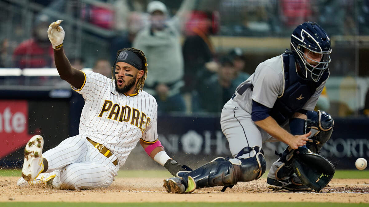 San Diego Padres’ Fernando Tatis Jr. scores on a single by Eric Hosmer as Seattle Mariners catcher Tom Murphy waits for the throw during the first inning of a baseball game Friday, May 21, 2021, in San Diego. (AP Photo/Gregory Bull)
